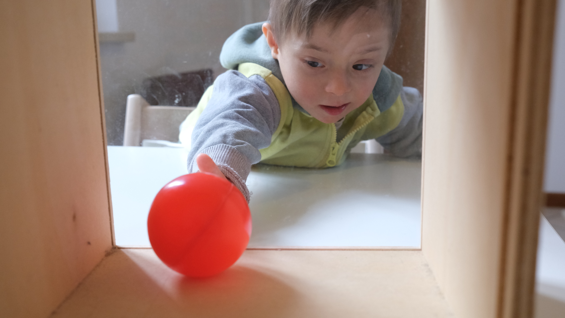 bambino affetto da sindrome di down gioca con una palla
