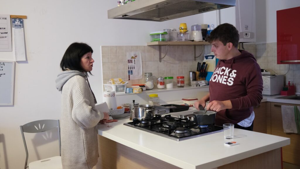 due persone che hanno una conversazione mentre cucinano
